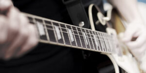 Left handed guitar being played, closeup of fingerboard
