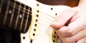 Left handed guitar being played, closeup of neck pickup