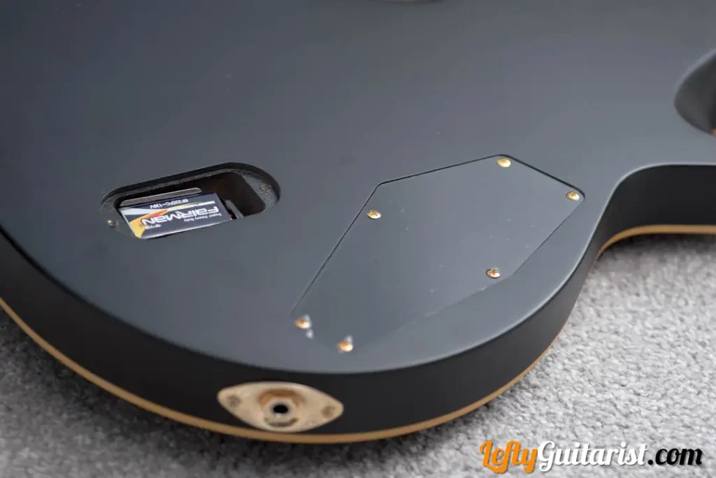 The back of a left handed ESP LTD EC-1000 in Vintage Black finish. It has compartment for a 9V battery to power its EMG pickups.