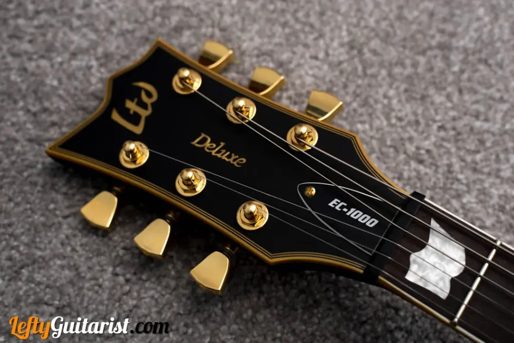 Headstock of a left handed ESP LTD EC-1000 in Vintage Black finish. It has gold tuners