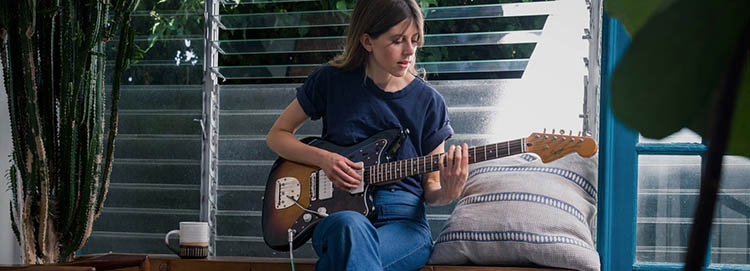 Woman playing a Fender Squier Jazzmaster