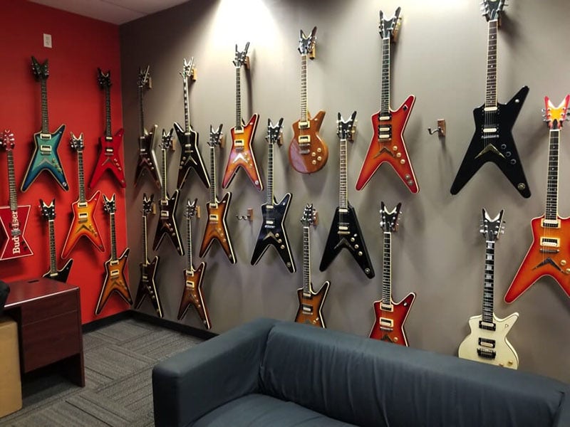 A wall, mounted with 22 Dean guitars